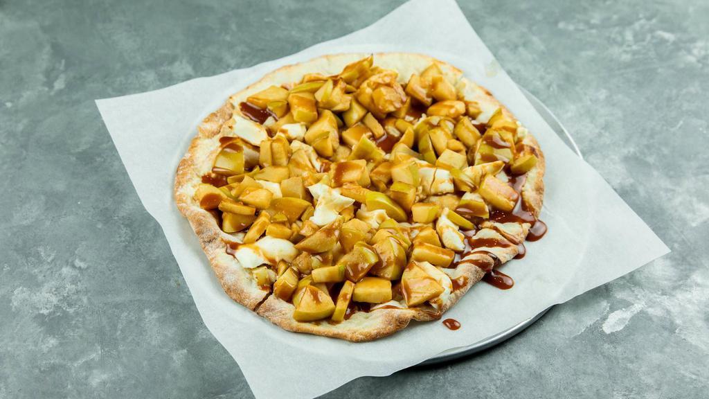 ROASTED CARAMEL APPLE PIZZA · Lightly sweetened pizza dough topped with cream cheese, roasted apples & finished with caramel drizzle.