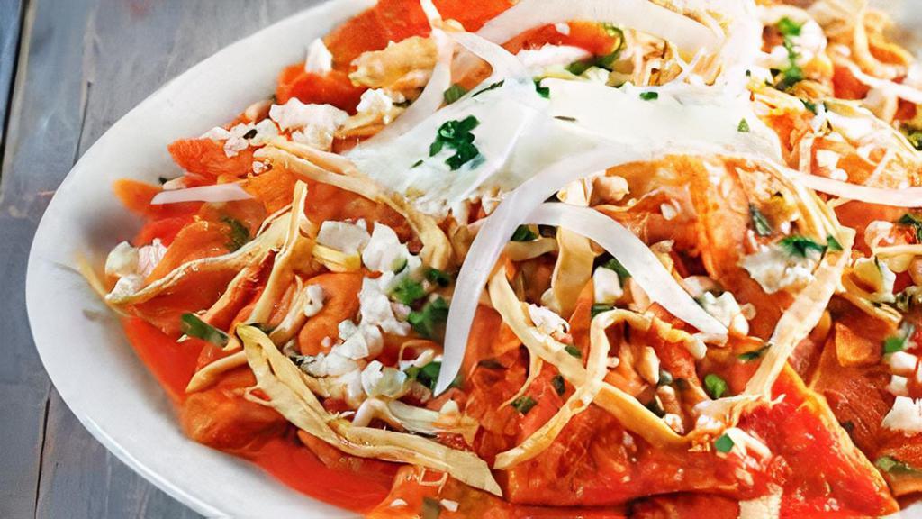 Chilaquiles · Strips of fried corn tortillas simmered in salsa, topped with eggs, cheese, onions, and cilantro. Served with potatoes a la mexicana and beans.