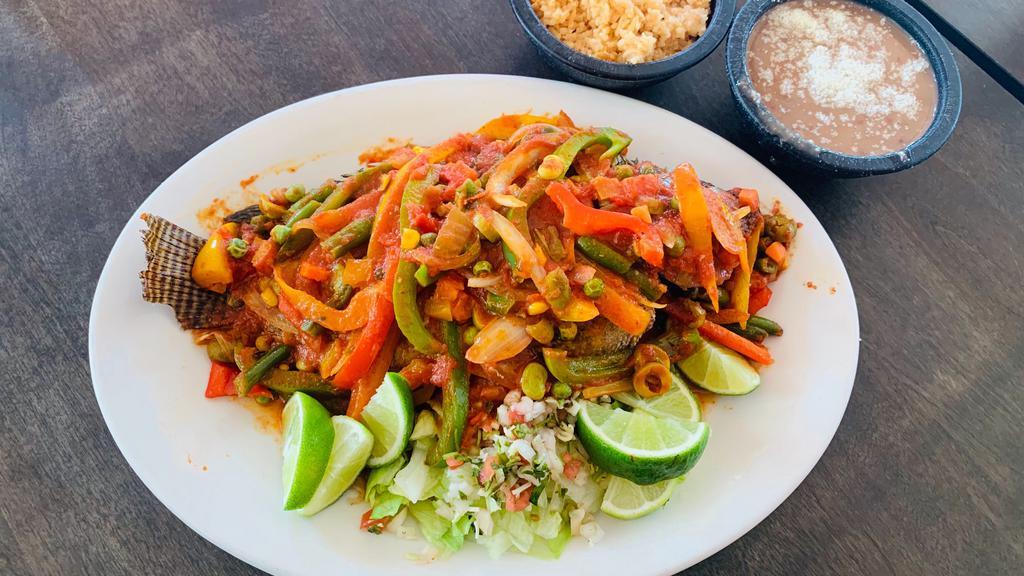 Mojarra Veracruzana · Crispy Whole Tilapia, topped with tomato sauce bell peppers, olives and onions.
