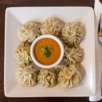 Chicken MoMo with Jhol · Traditional Nepali hog plum based chilled sauce served on the side for togo.
