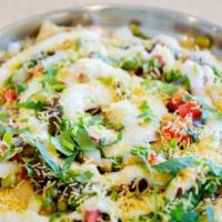 Papdi Chat · Puries topped with yogurt, moong, chana, potatoes, sev and chutneys.