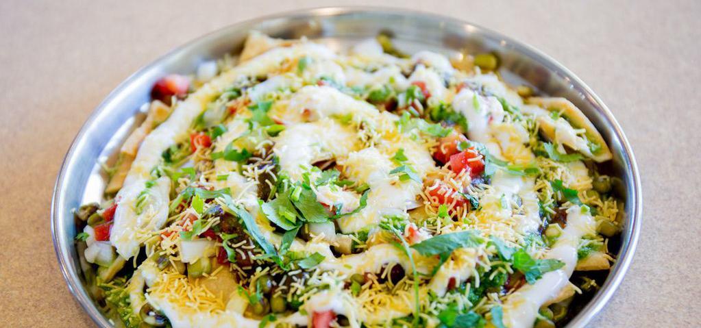 Papdi Chat · Puries topped with yogurt, moong, chana, potatoes, sev and chutneys.