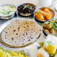 Kathiyawadi Thali · Combo: 2 bajra (pearl millet) rotlas, 2 vegetable curries, 1 kathod (lentil), 2 appetizers, ...