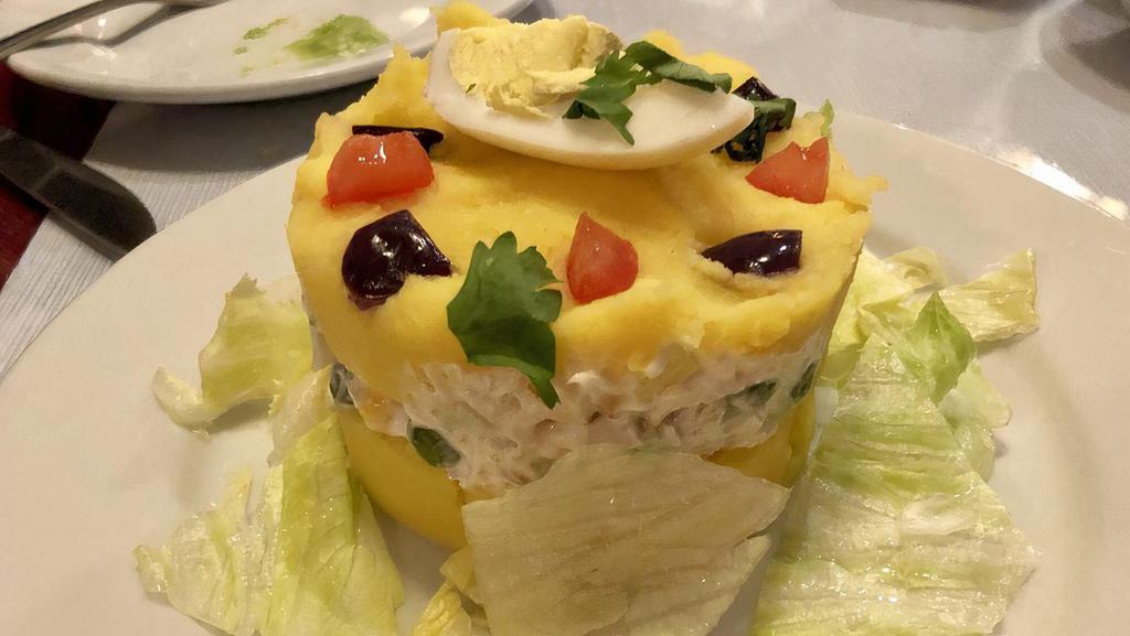 Causa Rellena · Mashed potatoes stuffed with chicken, salad, mixed vegetables. Served cold.