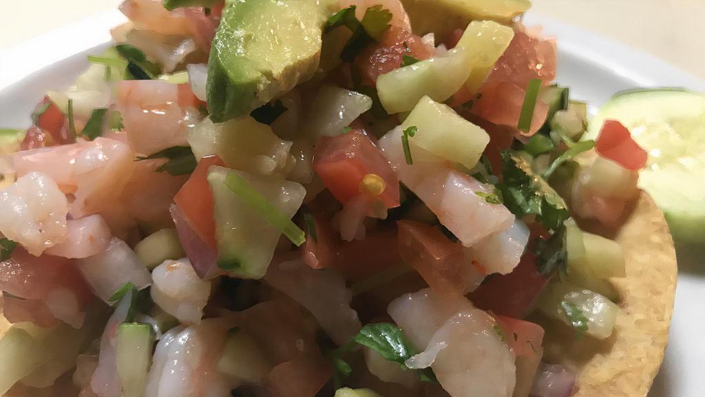 Tostada de Camaron Cocido · Cooked shrimp marinated in lime juice with fresh tomato, onion, cilantro, and topped with avocado slices. Served with tostadas.