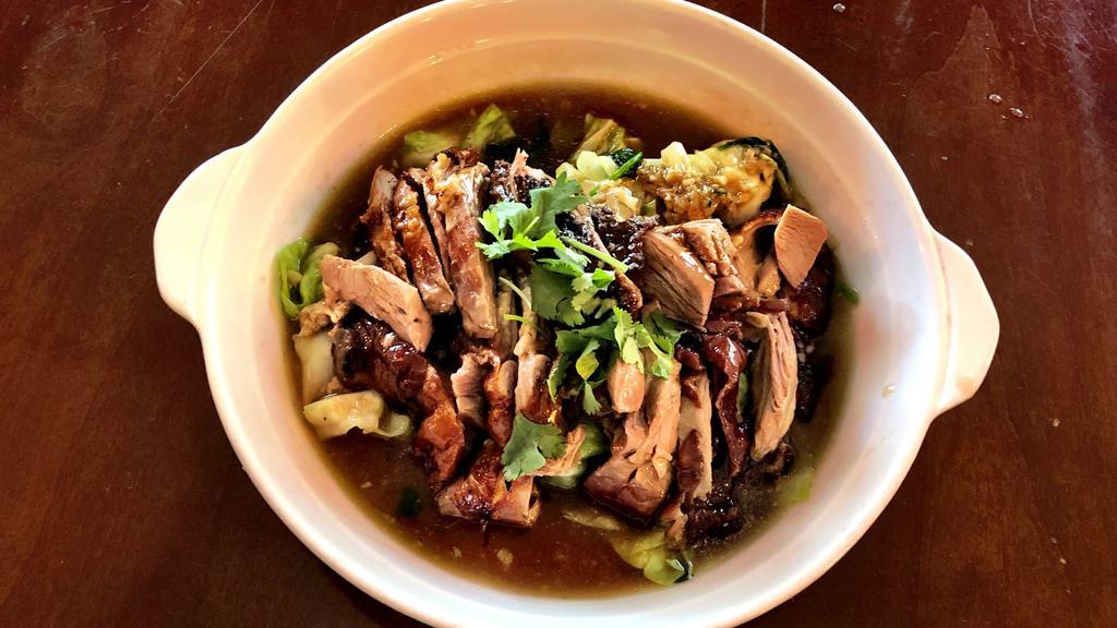 56. Ped Sawan (Roasted Duck) · Marinated boneless roasted duck in honey sauce, served on a bed of spinach and cabbage.