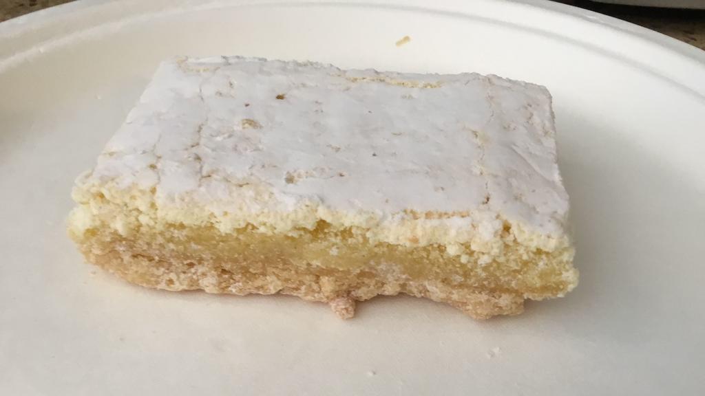 Lemon Bar · A shortbread crust topped with sweet, tangy lemon filling lightly dusted with powdered sugar.