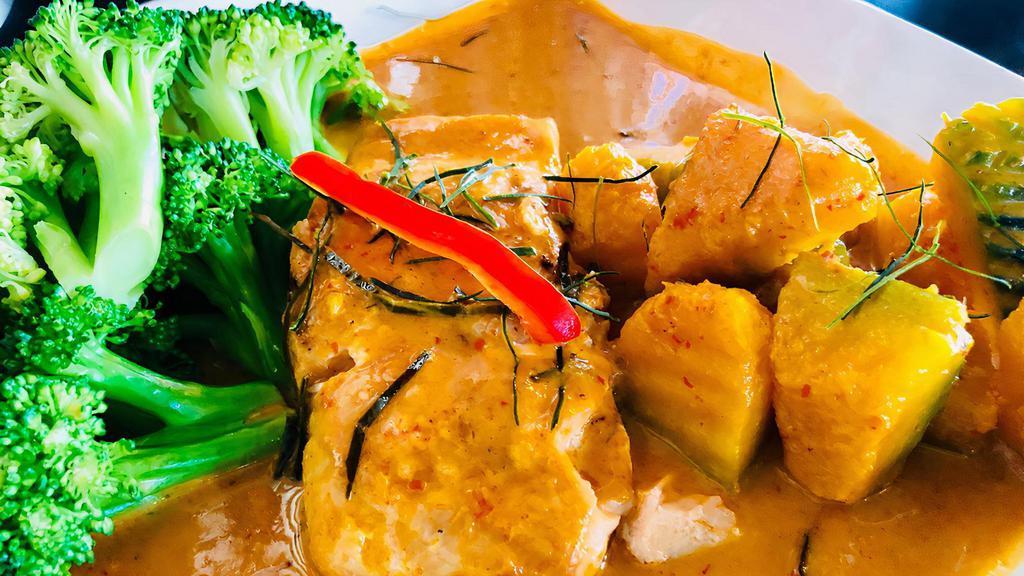Chu Chee Salmon · Fillet of salmon simmered in aromatic creamy chu chee curry sauce, steamed broccoli, pumpkin, sweet basil leave and touch of kaffir leaves.