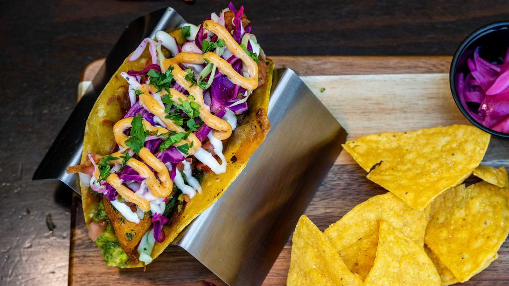 Fish Street Taco · Wild Iceland cod battered by hand, grilled jack cheese, house-made guacamole, pesto cilantro sauce, fresh pico de gallo, chipotle garlic aioli, sour cream, mixed cabbage, served on a warm golden blend tortilla and a side of pickled red onions and salsa.