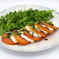 Caprese Salad · Fresh mozzarella, sliced tomatoes, basil, and arugula.