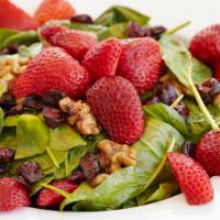 Spinach Salad · Leaves of spinach, caramelized walnuts, strawberries, dried cranberries and a champagne rasp...