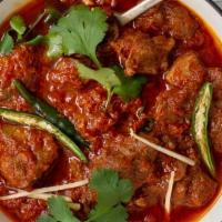 64. Lamb Karahi · Lamb sautéed with tomatoes, bell pepper, and spices in a traditional pan.