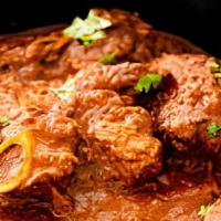 65. Goat Karahi · Goat sautéed with tomatoes, bell pepper, and spices in a traditional pan.