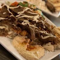 Gyro Platter · Classic spit-roasted gyro plate. Placed on a bed of aromatic rice. Plate comes with a pita b...