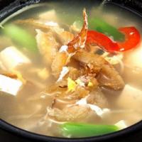 Book-Uh Gook · Dried pollack soup served with bean sprouts and tofu. Soup made with ox bones by simmering o...