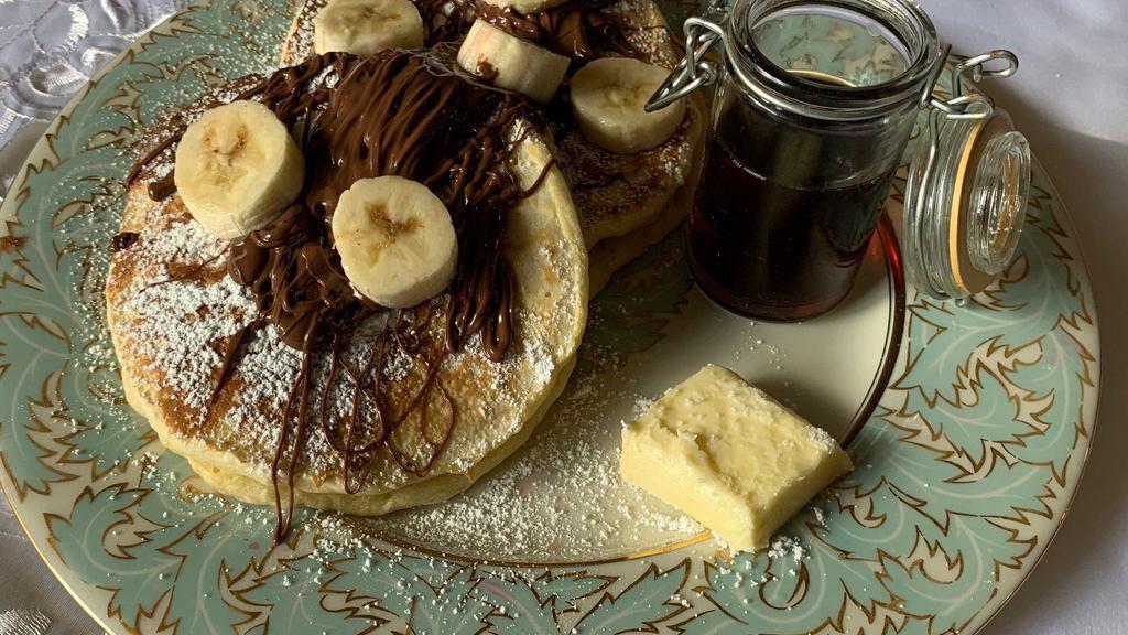 Nutella Banana Buttermilk Pancakes · 2 large buttermilk Nutella- banana pancakes with syrup and butter.
