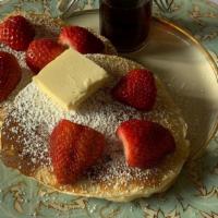 Strawberry Buttermilk Pancakes · 2 large buttermilk strawberry pancakes with syrup and butter.