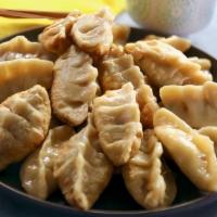 Chicken Potstickers (เกี้ยวซ่า) · Pan-fried dumplings stuffed with chicken and vegetables, served with roasted garlic sweet an...