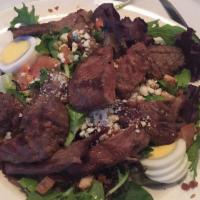Steakhouse Chef Salad · Fresh greens topped with tender steak, crumbled bacon, gorgonzola, diced tomatoes, and boile...