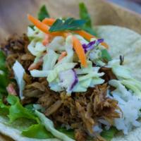 Adobo Taco · Pulled chicken or pork adobo with rice, coleslaw & cilantro on white corn tortilla.