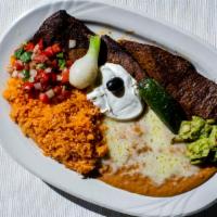 Carne Asada · A slice of juicy top sirloin, char-broiled and accompanied with guacamole, sour cream, and p...