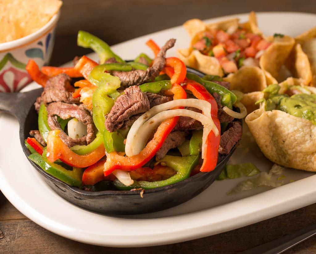 Fajitas · Strips of tender steak, chicken breast or a combination of both sautéed with spices, bell peppers, onions, and tomatoes, presented at your table in a sizzling iron skillet accompanied with refried beans guacamole, pico de gallo and your choice of corn or flour tortillas to build your own soft tacos.