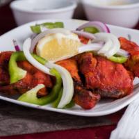 Tandoori Chicken · Leg piece marinated in yogurt and spices and roasted.
