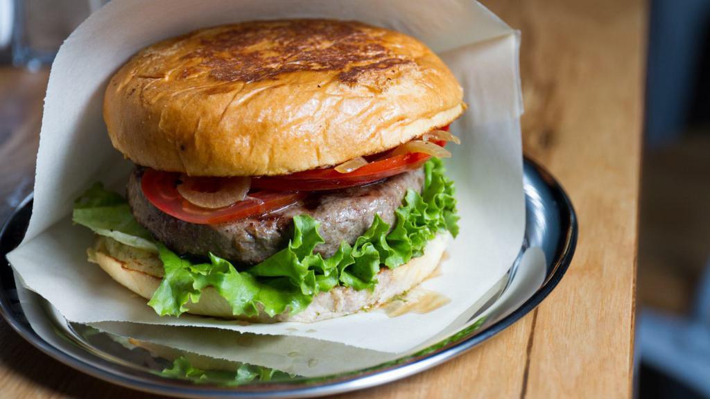 The Lamb Burger · Premium, 1/2 pound juicy, grilled lamb burger (natural and sustainably raised from Niman Ranch) with roasted garlic, olive oil and tangy feta cheese. Served on a buttered toasted bun with fresh spring mix, tomato, onions and mint yogurt sauce.