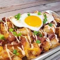 Loaded Tots · Mountain of tots topped with a fried egg, bacon, cheese, grilled onion, and Sriracha Aioli.