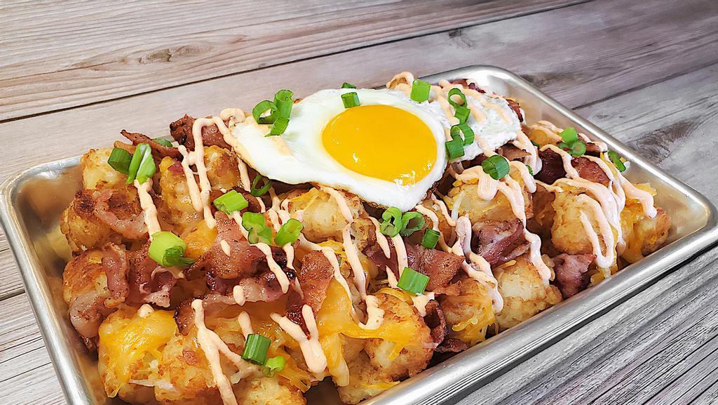 Loaded Tots · Mountain of tots topped with a fried egg, bacon, cheese, green onion, and Sriracha Aioli.