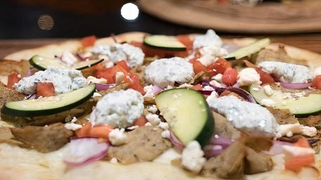 Chicken Gyro Pizza · White pizza sauce marinated chicken gyro meat tomatoes cucumber feta cheese and drizzles with classic tzatziki sauce.