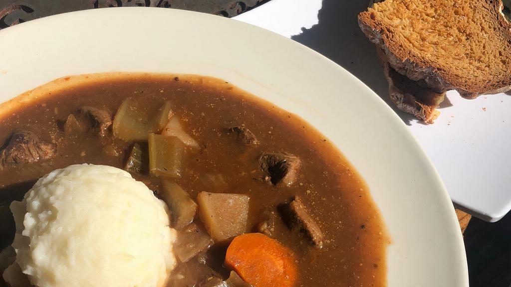 Guinness Irish Stew · Chunks of lamb stewed with root vegetables and topped with mash. Served with brown bread.