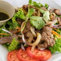 15. Beef Salad · Grilled beef served on top of cucumber, tomatoes, red onions, carrots, and lettuce with a mi...