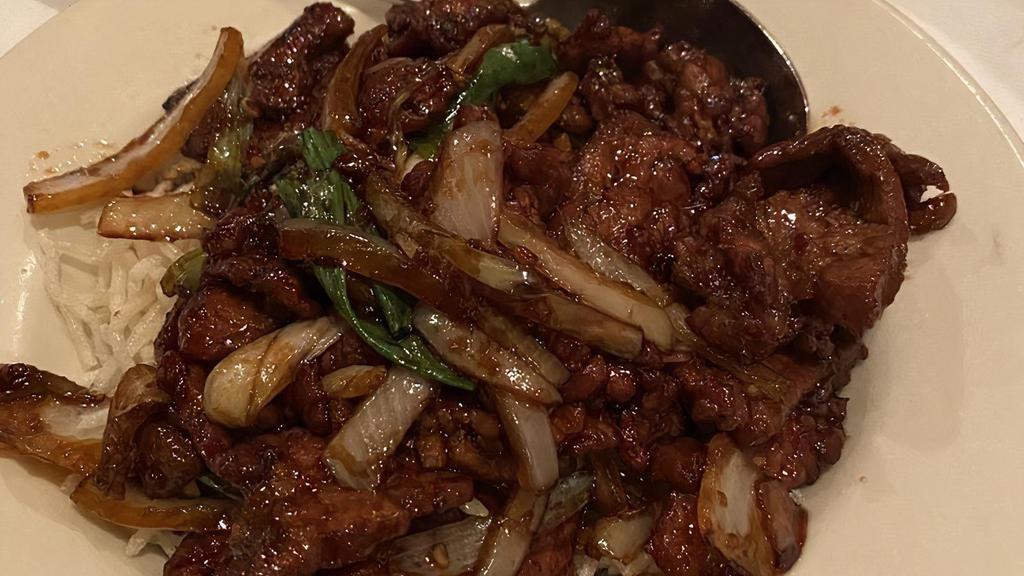 Mongolian Beef · Hot and spicy. Tender beef sautéed in a spicy dark sauce with green onions, white onions, and red chillies.