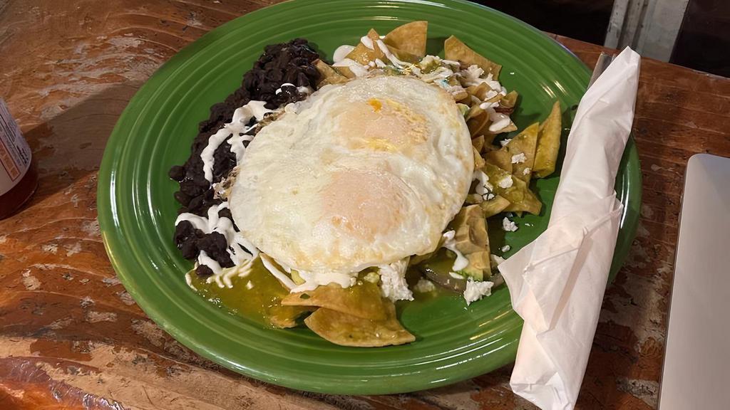 Chilaquiles · House made tortilla chips topped with two over easy eggs, queso fresco, green tomatillo, and sour cream. Served with a side of black beans.