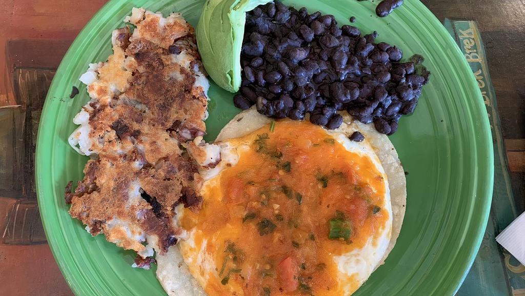 Huevos Rancheros · corn tortilla topped with two eggs, black beans,  avocado, and housemade sauce.