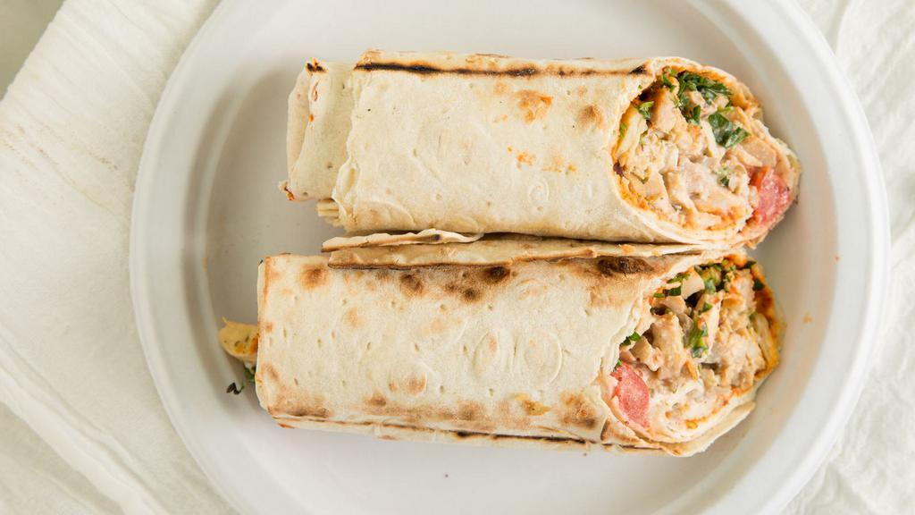 Chicken Shawarma Wrap · Chicken shawarma, grilled tomatoes, seasoned onions, pickles, garlic yogurt sauce topped with tahini on lavash bread