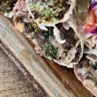 Lamb Shawarma Wrap · Lamb shawarma, grilled tomatoes, seasoned onions, pickles, parsley, topped with tahini on la...