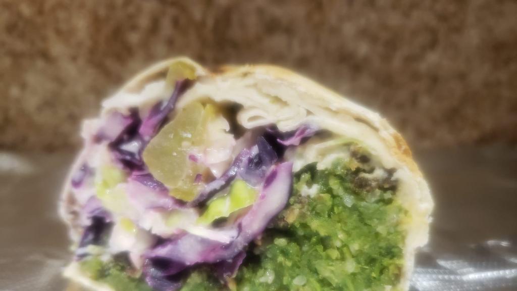 Lux Falafel Wrap (VEGAN) · Falafel, hummus, fried eggplant, potato, pickles, tomatoes, red and white cabbage, topped with tahini sauce on lavash bread.