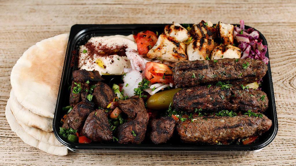 Kabob Sampler Plate  Chicken + Lamb + Kefta · A meat lover favorite for you get the taste of chicken, lamb, and ground beef kabab along with rice, hummus, and tabouli, jerusalem  salad, seasoned onions, and grilled tomatoes.