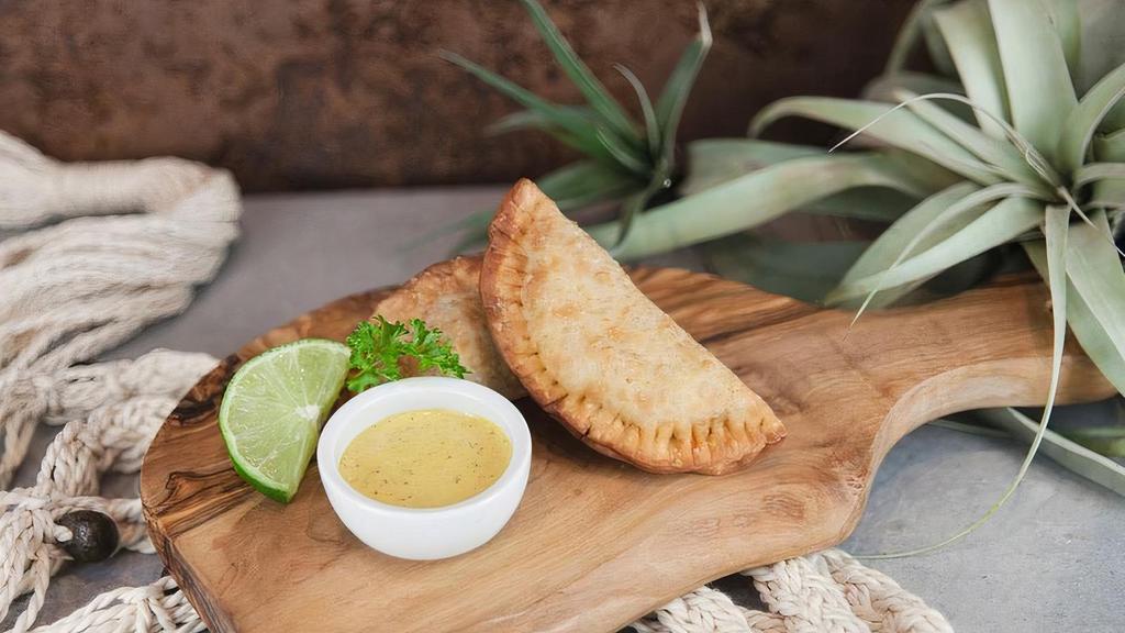 Beef empanadas · Two crispy pastries filled with: Hand cut top sirloin sauteed in aji Panca, eggs, olives, & raisins.