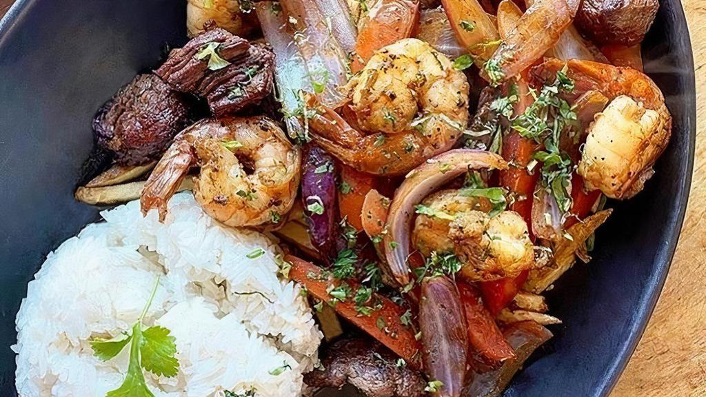 Mar y tierra (surf & turf) · Wok stir-fried (4) shrimp & beef tenderloin with onions, tomatoes in ginger infused soy sauce, & french fries. Served with jasmine rice.. *NOT Gluten Free. *Contains shellfish (oyster sauce) & Soy