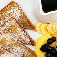 La Tradition · French bread dusted with powdered sugar and topped with whipped cream served  with fruit