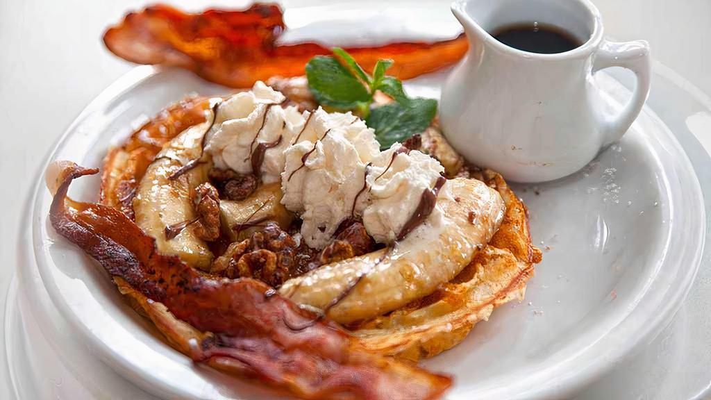Louise Waffle · Bananas foster walnuts  with Nutella, caramel and Bacon. Served with syrup