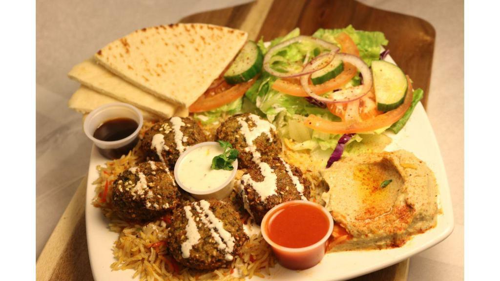 Falafel Platter · 5 Falafels, Salad, Rice, Hummus, Tahini Sauce, Pita Bread with Side of Tazitki and Spicy Sauces.