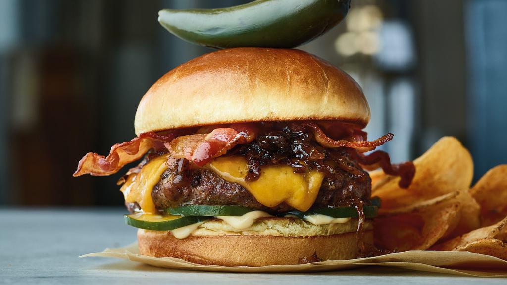 Bacon Bomb Burger · Beef burger, bacon onion jam, crispy bacon, Cheddar cheese, house-made pickles, aioli. Served with perfectly seasoned crispy fries.