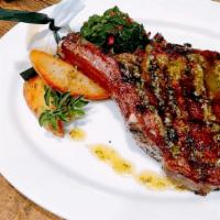 Mosharisia Brizola/Rib Eye Steak · 22 oz. Charcoal grilled dry-aged rib-eye with braised greens and Evvia potatoes.