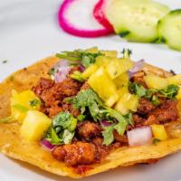 Al Pastor Taco · Corn tortilla, marinated pork, cilantro, onions, and pineapple. Complimentary garnish: radis...