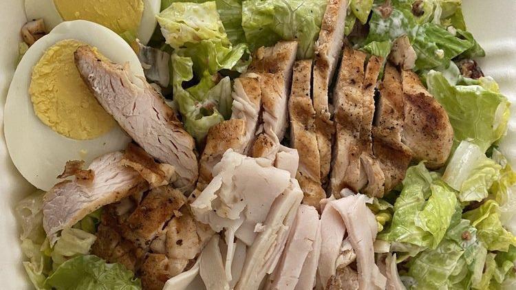Cobb Salad · Mixed greens topped with charbroiled chicken, turkey, bacon, egg, avocado, tomato, and crumbled blue cheese.