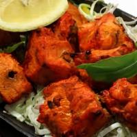 Fish Tandoori · Marinated fish with garlic, herbs, and spices, cooked in clay oven.